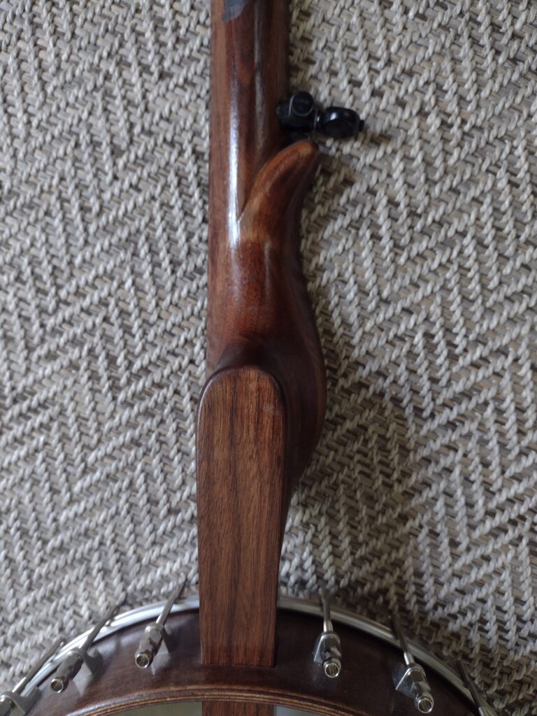 Carving on the back of a banjo neck 