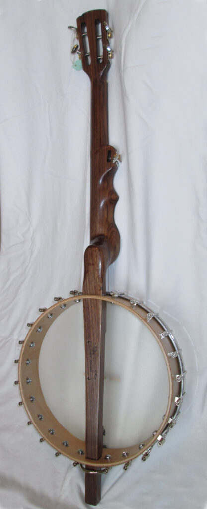 A five string banjo seen from the back. Neck carving contours are visible