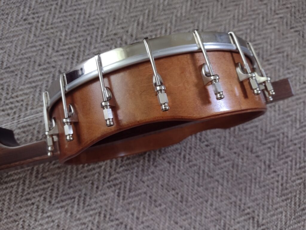 view of the rim of a five string banjo that features rib and hip comfort contours 
